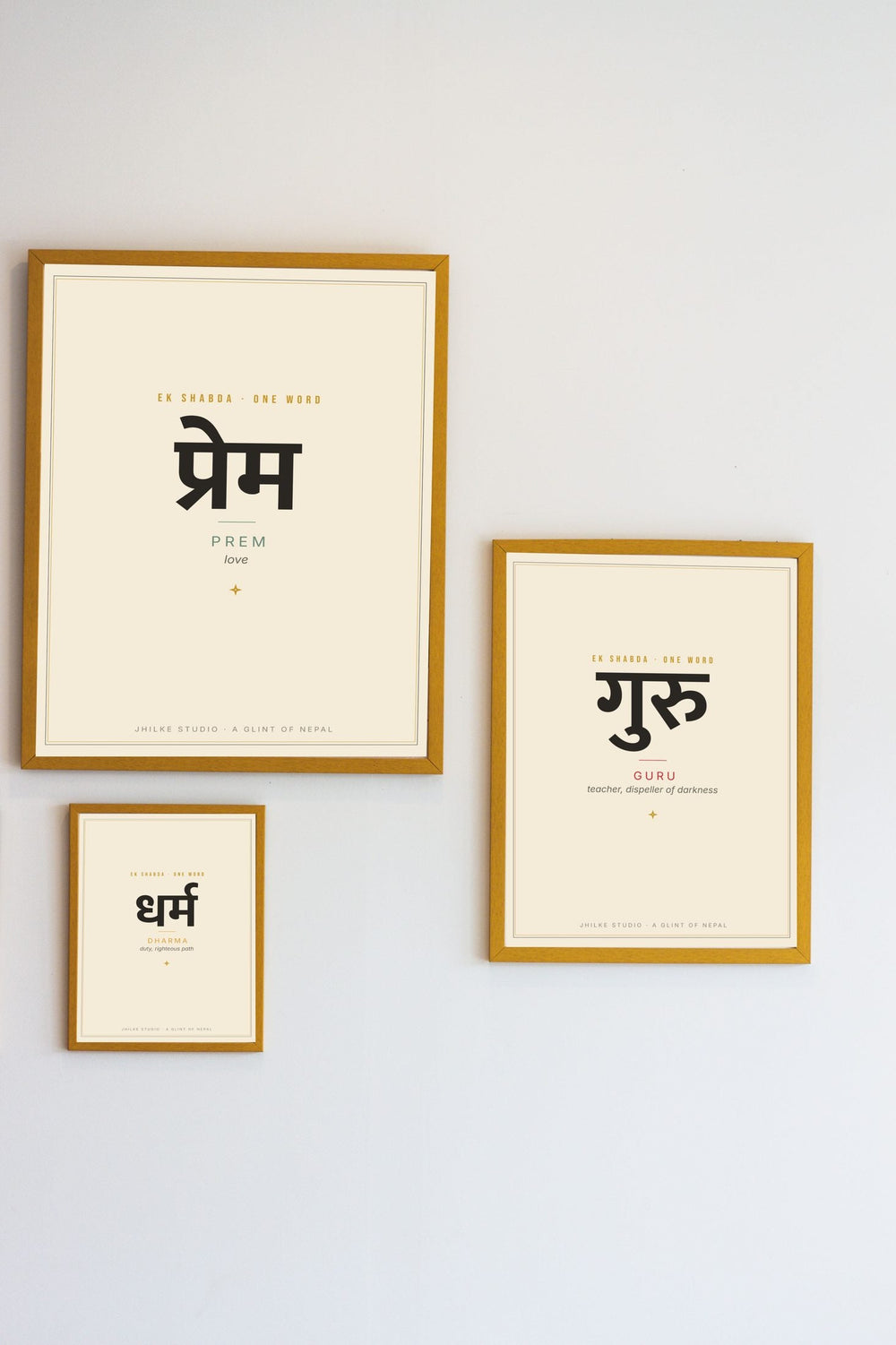Gold-framed One Word Devanagari prints on a wall