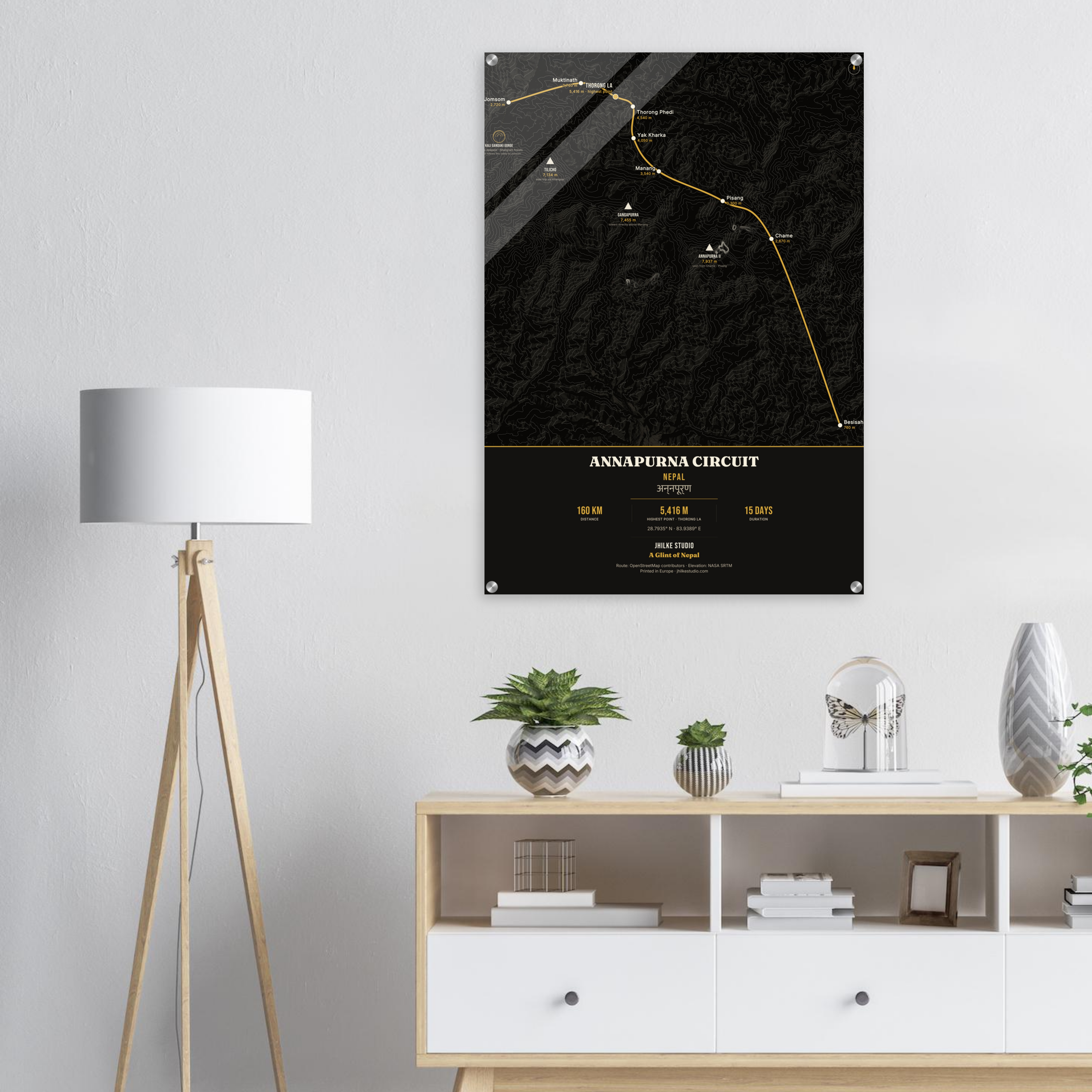 Annapurna Circuit trek route map in the dark colourway, shown as an acrylic glass print mounted on a wall. Jhilke Studio.