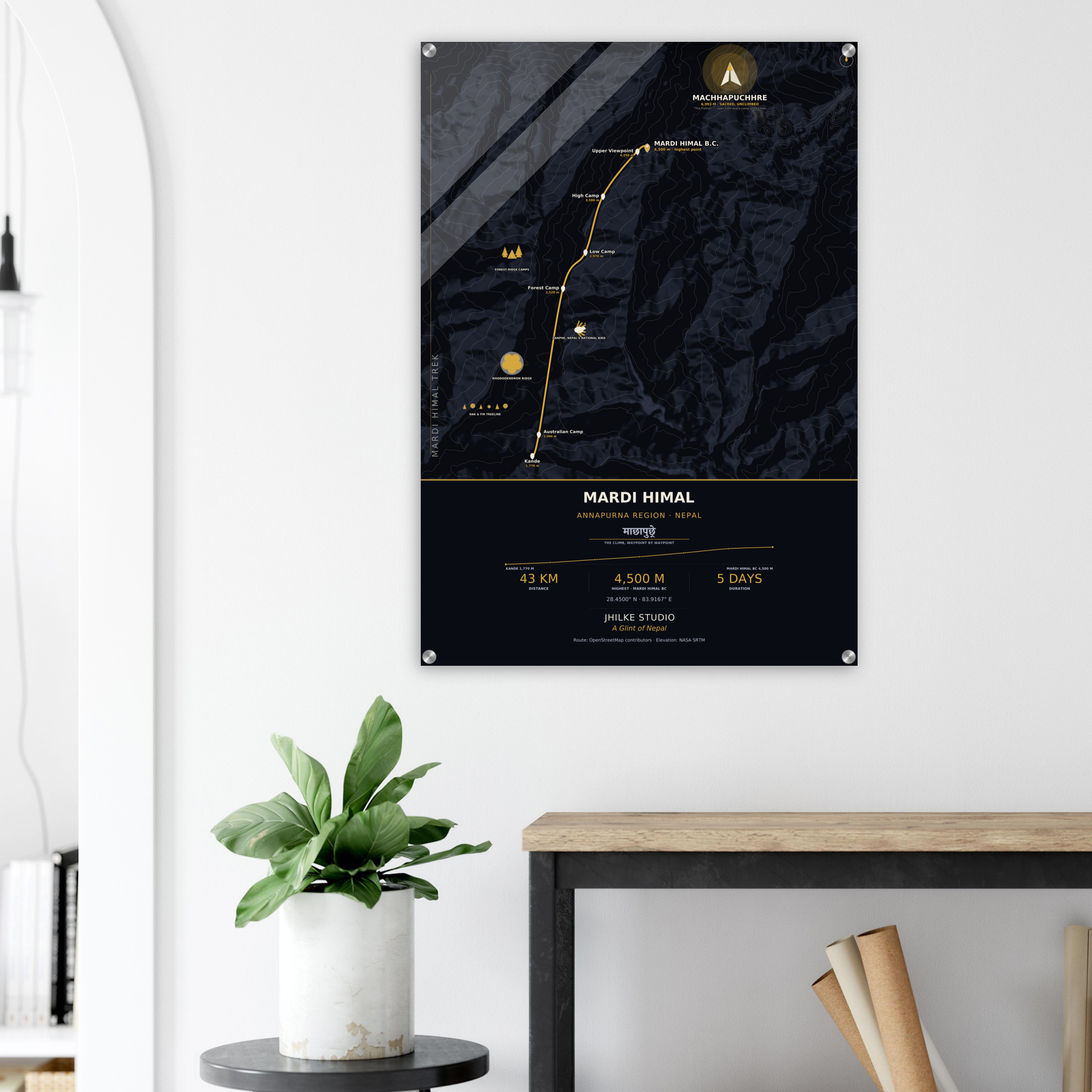 Mardi Himal trek route map in the dark colourway, shown as an acrylic glass print mounted on a wall. Jhilke Studio.